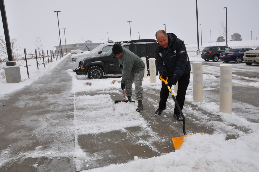 Hand Shovellers clearing commercial parking lot
